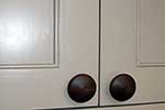 Painted kitchen doors with cock bead to panel and american black walnut knobs
